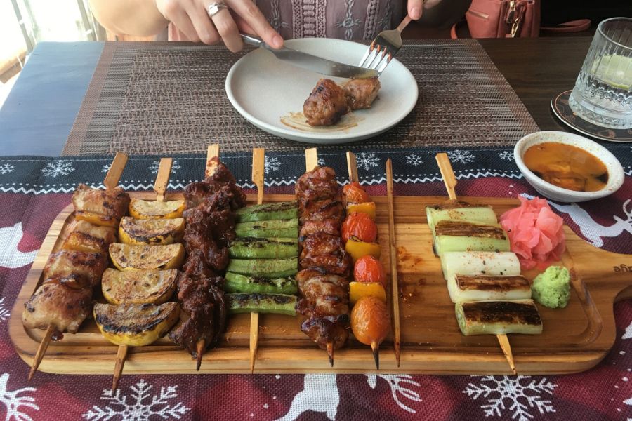 a mixed platter of meats and vegetables on sticks.