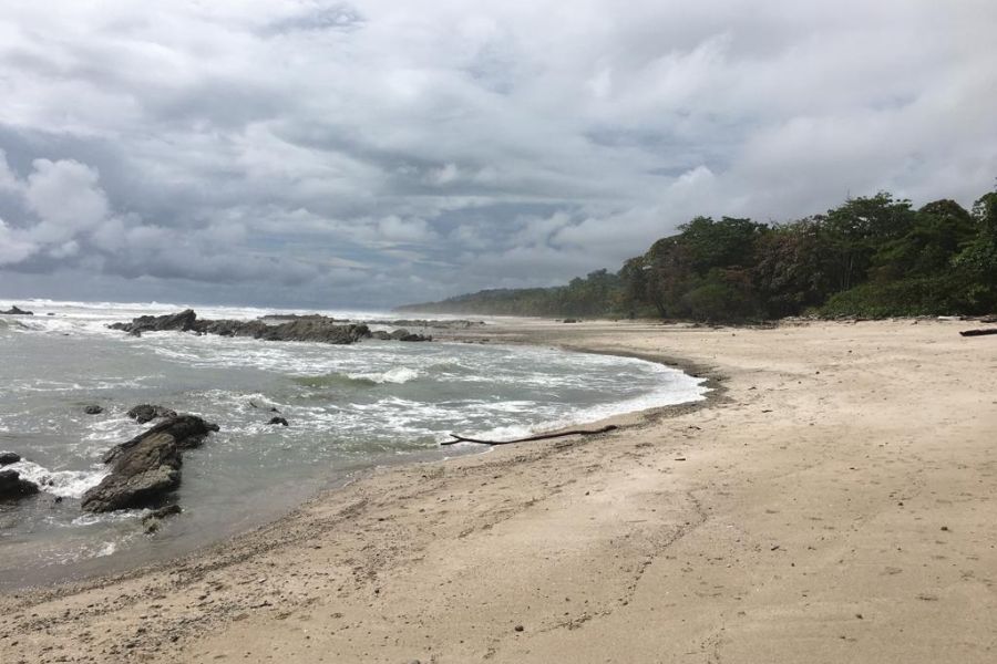 a beach scene with gloomy skies on the horizon