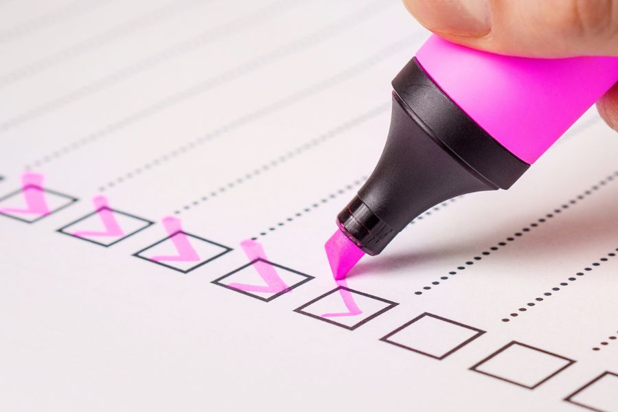 A pink highlighter pen ticks off boxes on a form