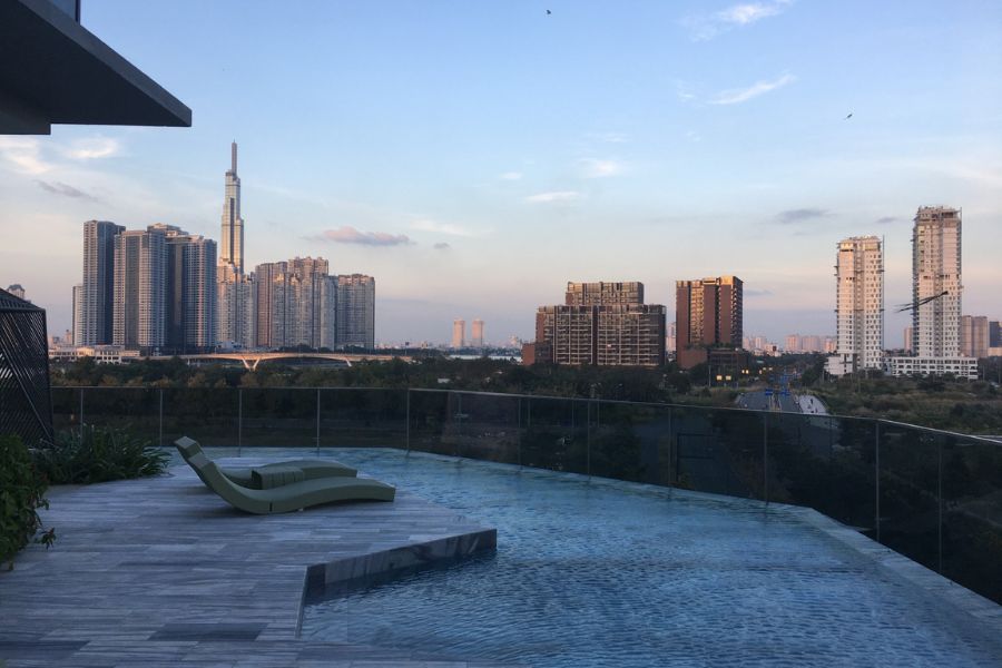 a stunning infinity pool looks out over Ho Chi Minh City Vietnam around dusk.