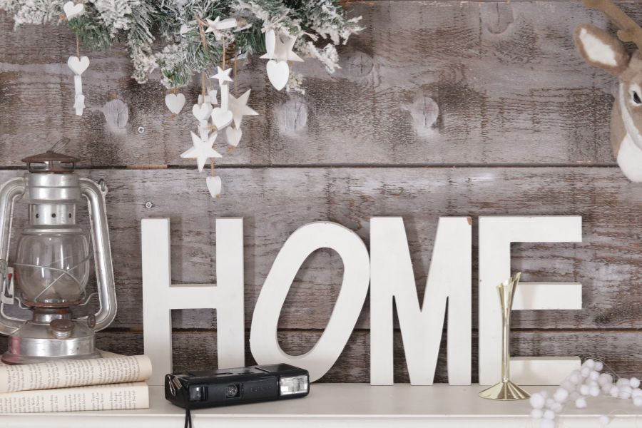 a sign on a shelf reads 'HOME'' also an old disposable camera and a lantern.