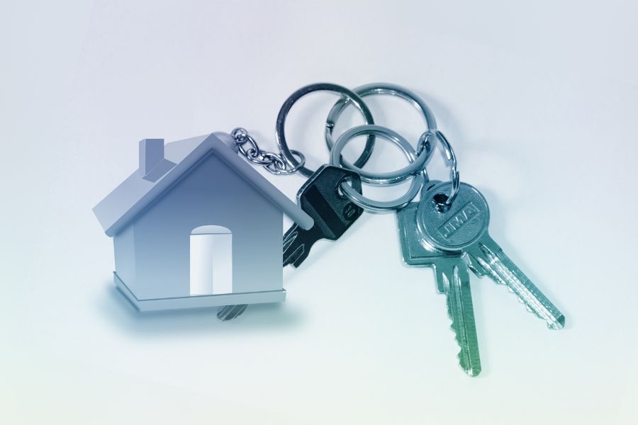 a small toy house and a set of keys set against a plain white background