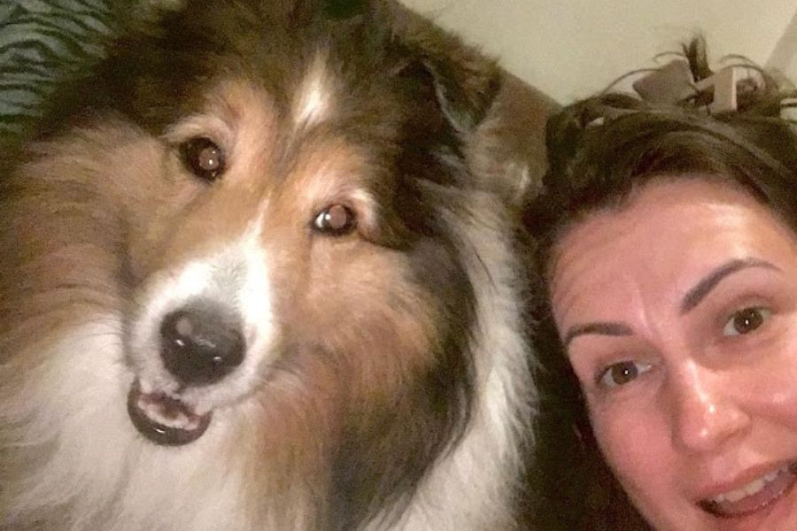 a woman and a dog pose for a close up selfie.