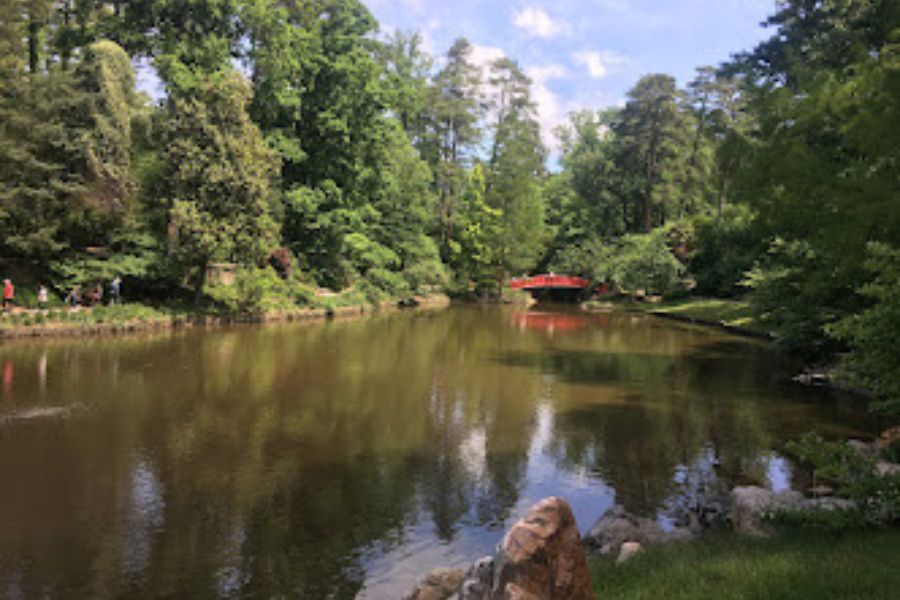 A tranquil and scenic lake with a red foot bridge in the distance