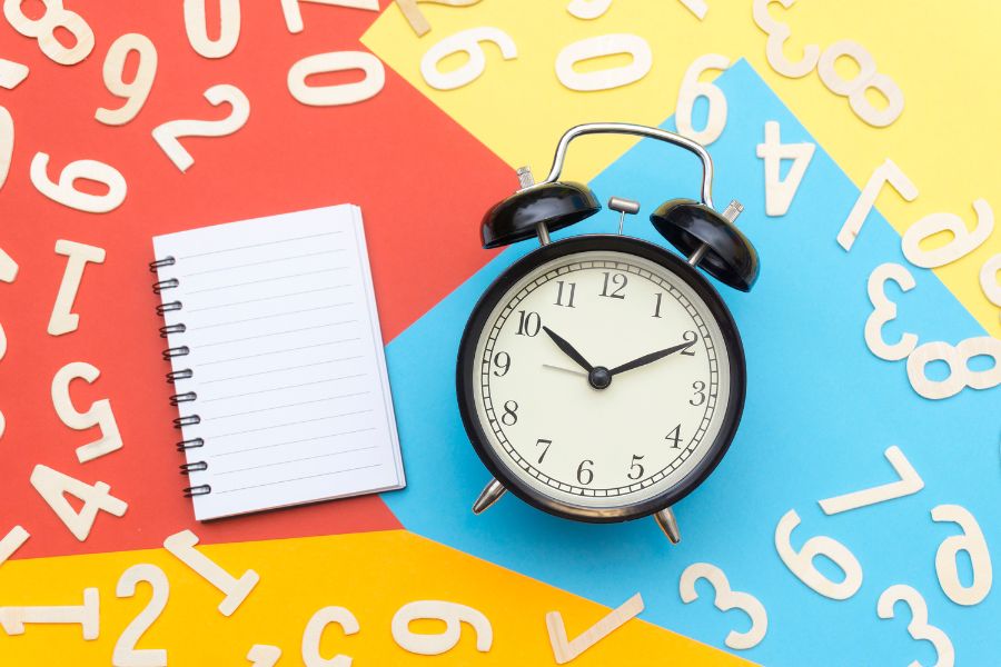 an alarm clock and a pad on a colorful backdrop