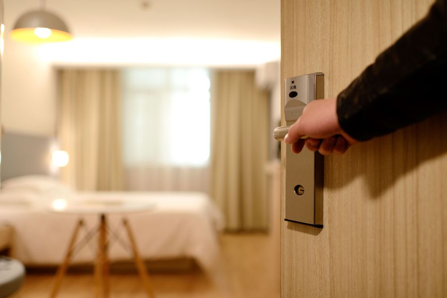 a hand opens a hotel room door