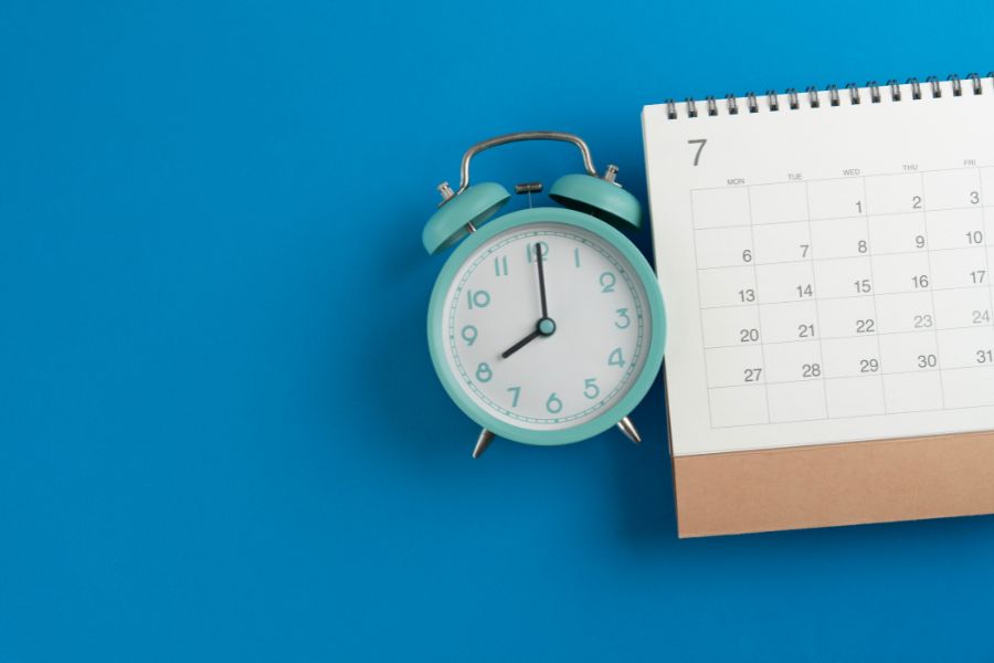 a clock and a calendar lay on a blue background