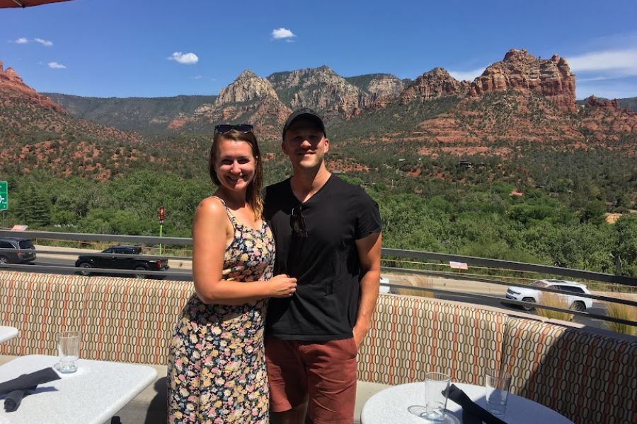 a couple pose for a selfie against the red rocks of Sedona on a beautiful clear day with blue skies