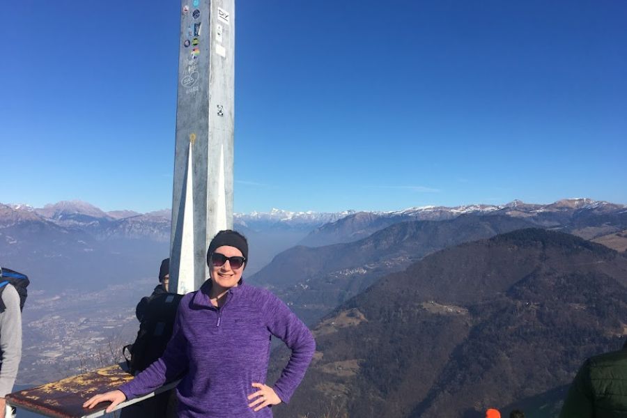 Woman smiles atop a mountain