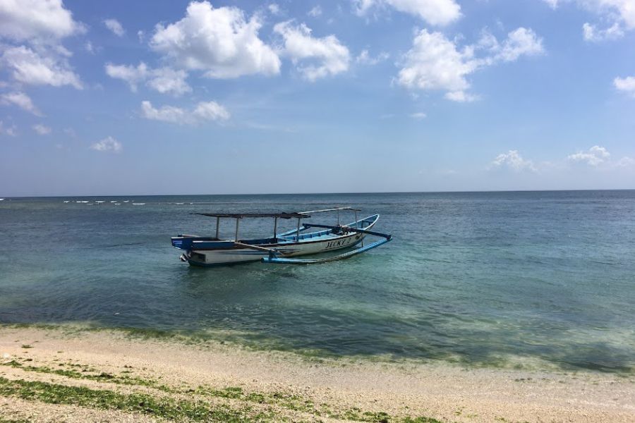 fishing boat floats on the blue surf