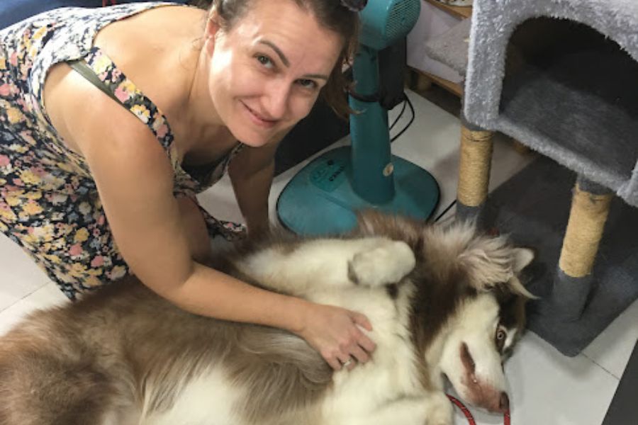 woman scratches a dog's belly.