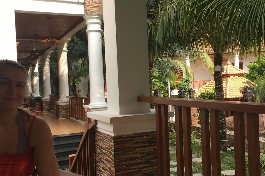 woman on porch surrounded by palm trees