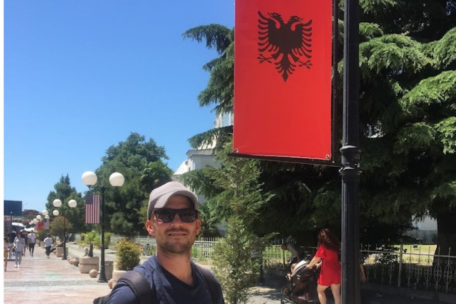 man in front of Albanian flag