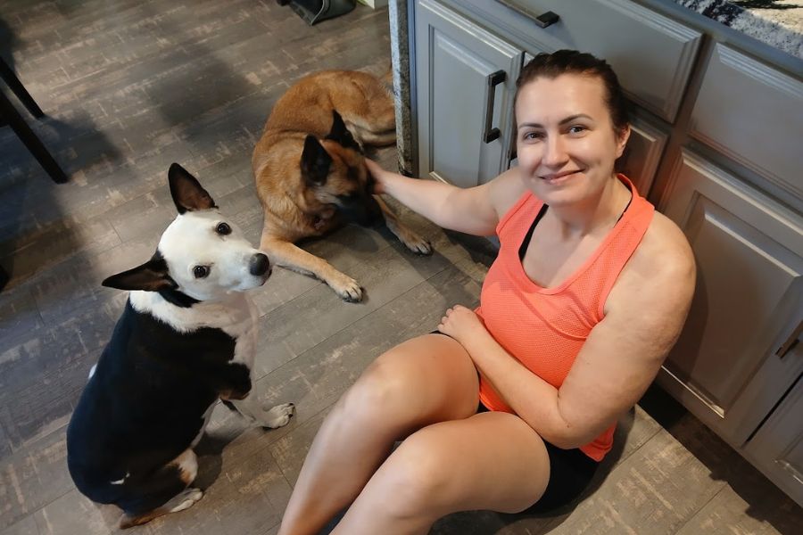 woman sitting on floor with 2 dogs