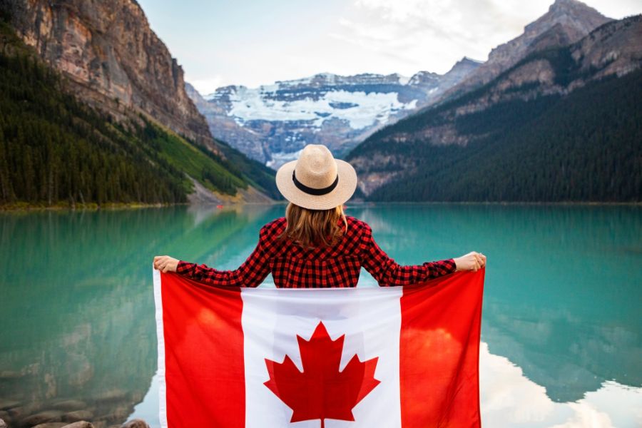 woman with Canadian flag by a lake